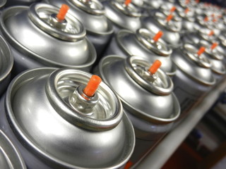 Close up of rows of aerosol cans in manufacturing factory