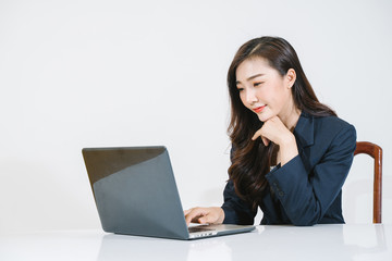 Successful girl manager in her own office makes a new economic development business plan on a laptop . A business woman with documents sits at a wooden table