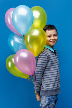 Emotional Little Boy Holding  Ballons On Blue Background. Little Child Is Going To Throw Somebody His Ballon