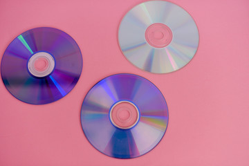 Assortment of compact disc isolated against pink background