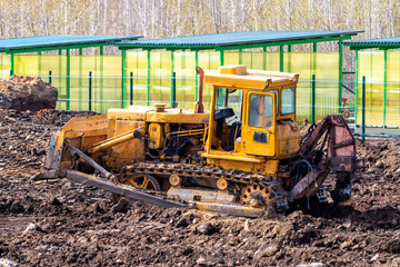 Fototapeta premium Yellow bulldozer leveling the ground at a construction site