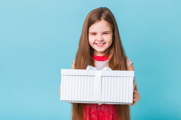 holidays, presents, christmas, childhood and birthday concept - smiling little girl with gift box over blue background