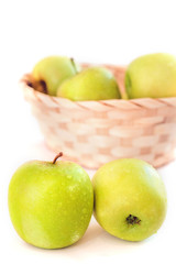 green apples in a basket on a white background, isolated