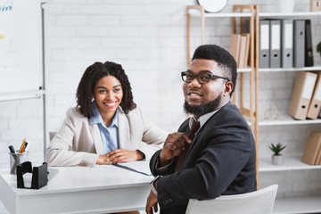 Cheerful African American guy having job interview with hiring manager at company office
