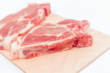 a piece of raw pork meat on a cutting Board is isolated on a white background, top view