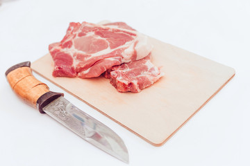a piece of raw pork meat on a cutting Board is isolated on a white background, top view