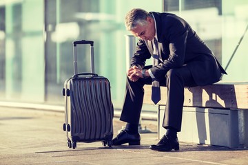 Portrait of businessman sitting while waiting for his pickup in airport 