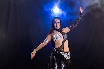 Young woman dancing in Tribal Fusion style. Belly dance on the stage.