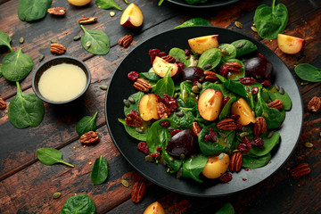Vegan plums salad with cranberry, pumpkin seed, pecans nuts, spinach and mustard dressing
