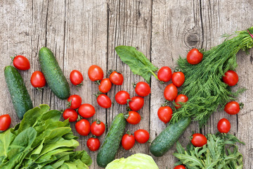 Vegetables and greens on a wood background