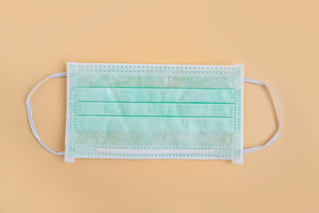 Medical mask isolated on color background. Green medical face mask protection against pollution, virus, flu, and coronavirus. Disposable surgical face mask cover mouth and nose. Health care concept.