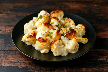 Oven baked Cauliflower cheese with bechamel sauce in black plate