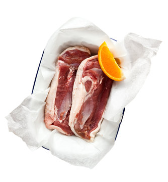 Fresh Raw Duck Breast Fillets With Orange Wedge Isolated On White