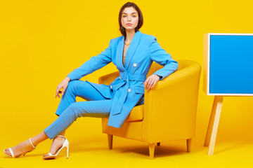 High fashion portrait of young elegant woman in blue suit.