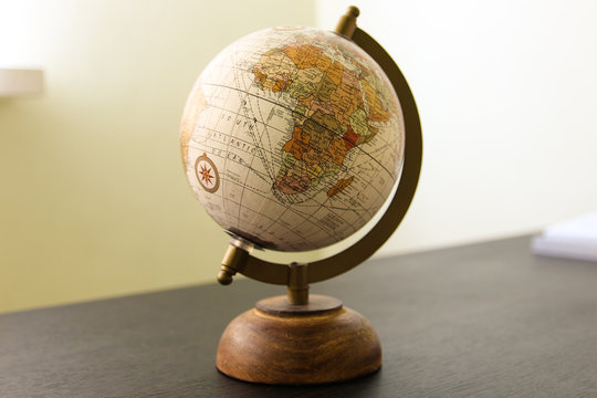 Globe model on the dark wooden table in the room