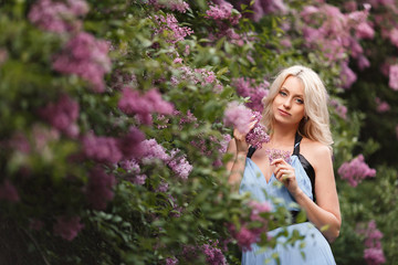 Beautiful adult woman in a flowering lilac