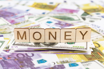 Wooden sign MONEY made of wooden alphabet letters, working concept. World map background