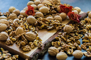 Shelled and shelled walnuts on a wooden board on the table. Healthy nutrition, vegetarianism, diet.