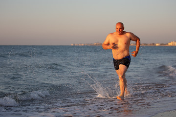 Fototapeta na wymiar An elderly man jogs along the coast.
