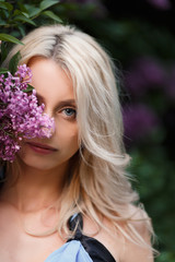 Beautiful adult woman in a flowering lilac