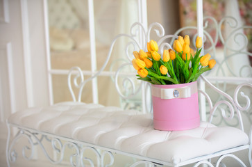 Pink box with yellow tulips in a white interior.