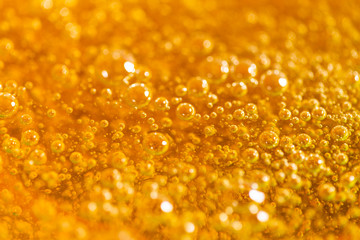 Detail of abstract orange bubble, can be used for background. Paste for sugaring close-up. Depilation and hair removal concept. Macro photo.