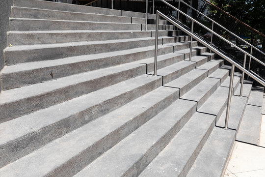 Tall Wide Concrete Staircase On A Building Exterior, Silver Stainless Railings, Horizontal Aspect