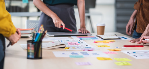 Fototapeta Close up ux developer and ui designer brainstorming about mobile app interface wireframe design on table with customer brief and color code at modern office.Creative digital development agency.panning obraz