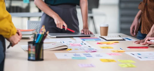 Foto op Plexiglas Close up ux developer and ui designer brainstorming about mobile app interface wireframe design on table with customer brief and color code at modern office.Creative digital development agency.panning © weedezign