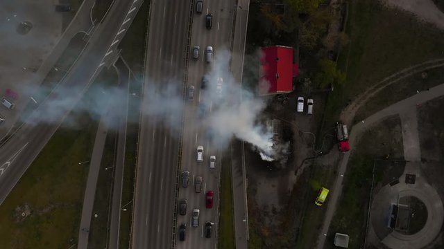 House burns and smokes at highway. Firefighters finish extinguishing fire aerial