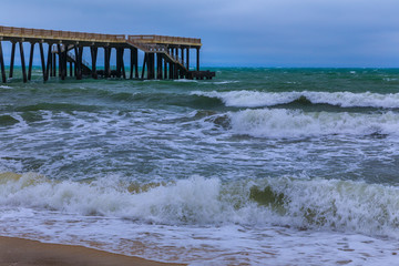 Pier on the coast going to sea in stormy weather