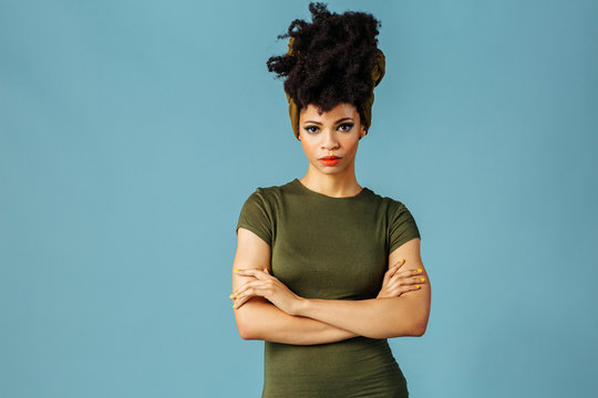 Portrait Of A Young Woman With Arms Crossed, Isolated In Blue Color Studio