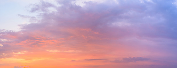 Naklejka na ściany i meble panorama of a blue-pink sunset with clouds of pink hues. sunset on the horizon. photo for the banner. space for text.