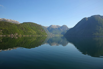 Beautiful landscape in the fjord, with reflections of the mountains in the water. Peace & tranquility, Rosendal, Hardangerfjord, Norway.