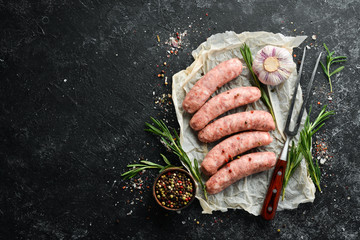 Raw barbecue sausages with spices and vegetables. Top view. Free space for your text.