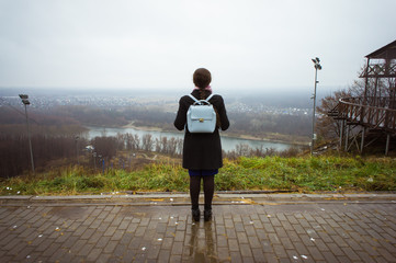 Autumn girl. back view Cheerful carefree autumn woman in park overcast weather.