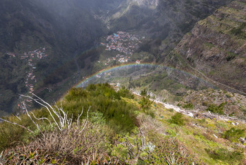 Fototapeta na wymiar Rainbow over Valley of the Nuns, Curral das Freiras on Madeira Island, Portugal