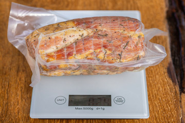 Pork ham in vacuum packaging on a wooden table