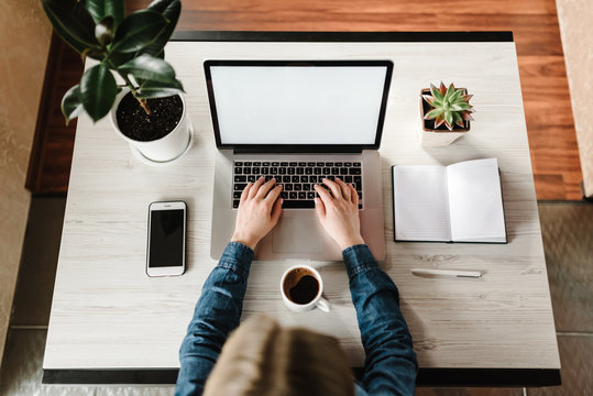 Woman working, learns, using laptop computer on table. Writing, typing. Blank screen, cell phone. Freelance concept. Work home. Online education, shopping. Communication, technology concept. Top view.