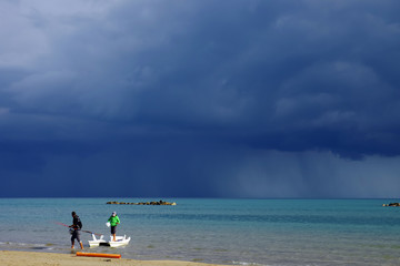 A man and a boy return from a fishing trip as a storm arrives on the horizon.
