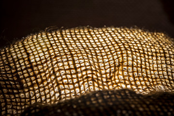 burlap background from which light is visible