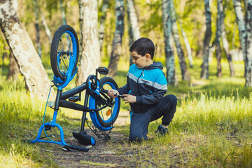 little boy cyclist shakes a broken wheel on a bicycle. DIY repair