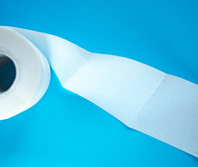 Toilet paper on blue background, top view. Hygiene stuff for everyday. Selective focus.