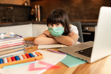 Schoolgirl study at home, social distance during quarantine, self-isolation, online education concept, home school. Online learning during pandemic Covid-19
