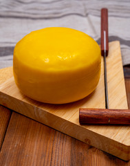 One small head of Dutch baby gouda cheese in yellow wax