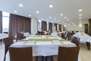 Tables and chairs in large restaurant hall. Empty room