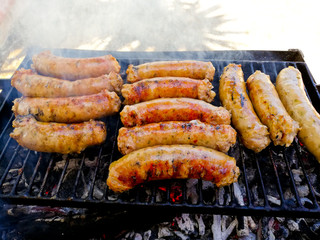Sausages on the barbecue grill with flames