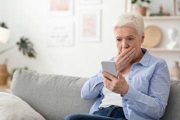 Fototapeta na wymiar Coronavirus News. Shocked Senior Woman Reading Information On Smartphone At Home