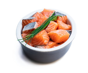 Fresh salmon fillet cubes in clay bowl isolated on white