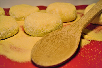 Billets of home cheesecakes on red culinary latex. And a wooden spoon